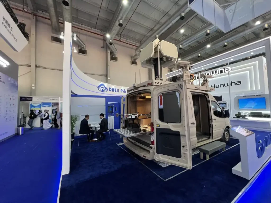 Wide-angle view of DAEJI P&I defense exhibition stand with surveillance vehicle display