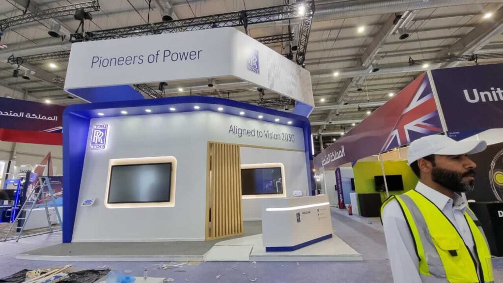 Rolls-Royce exhibition booth under construction featuring Vision 2030 branding and modern display installation.