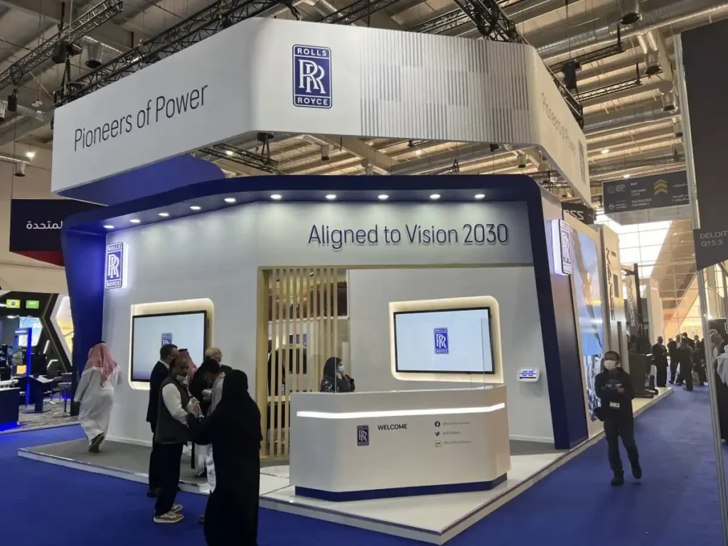Rolls-Royce exhibition stand with interactive displays and modern reception area at defense trade show.