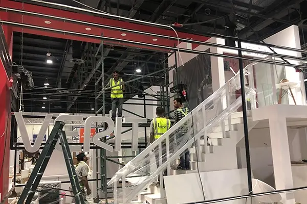 installation
Installation team assembling VERITAS exhibition booth with staircase, overhead frame, and branded structure