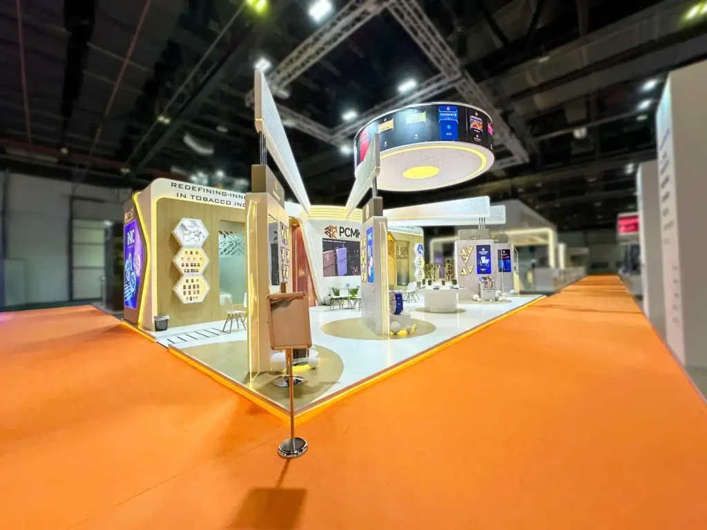 Wide-angle view of the PCMK Industries exhibition booth with illuminated product display zones.