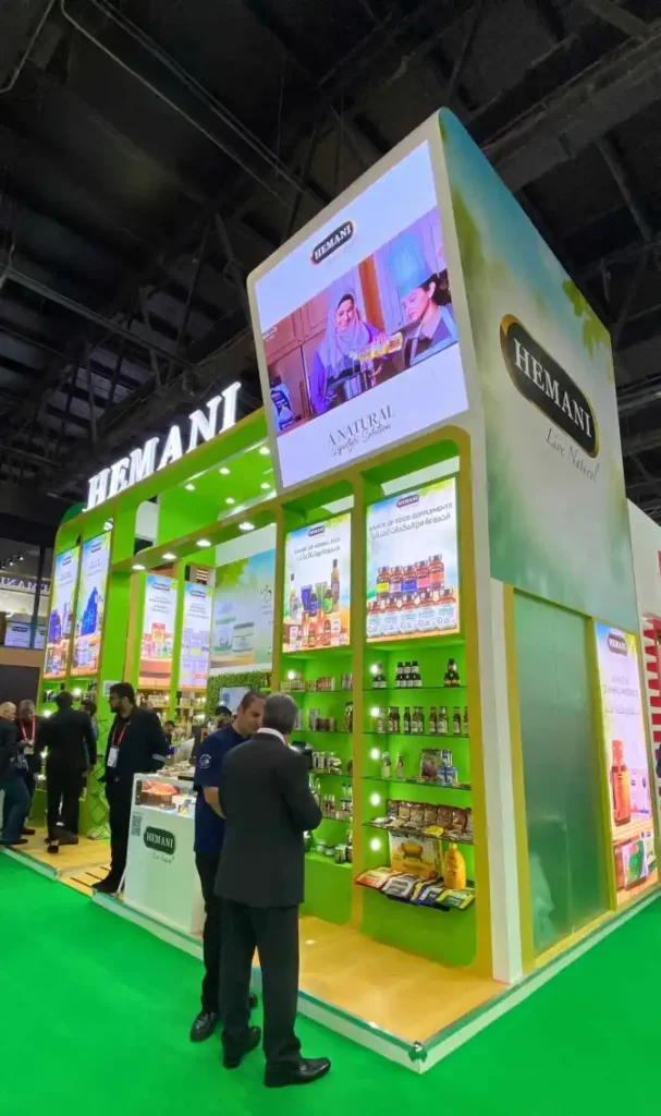 Hemani exhibition stand with illuminated branding and natural health product displays at trade show