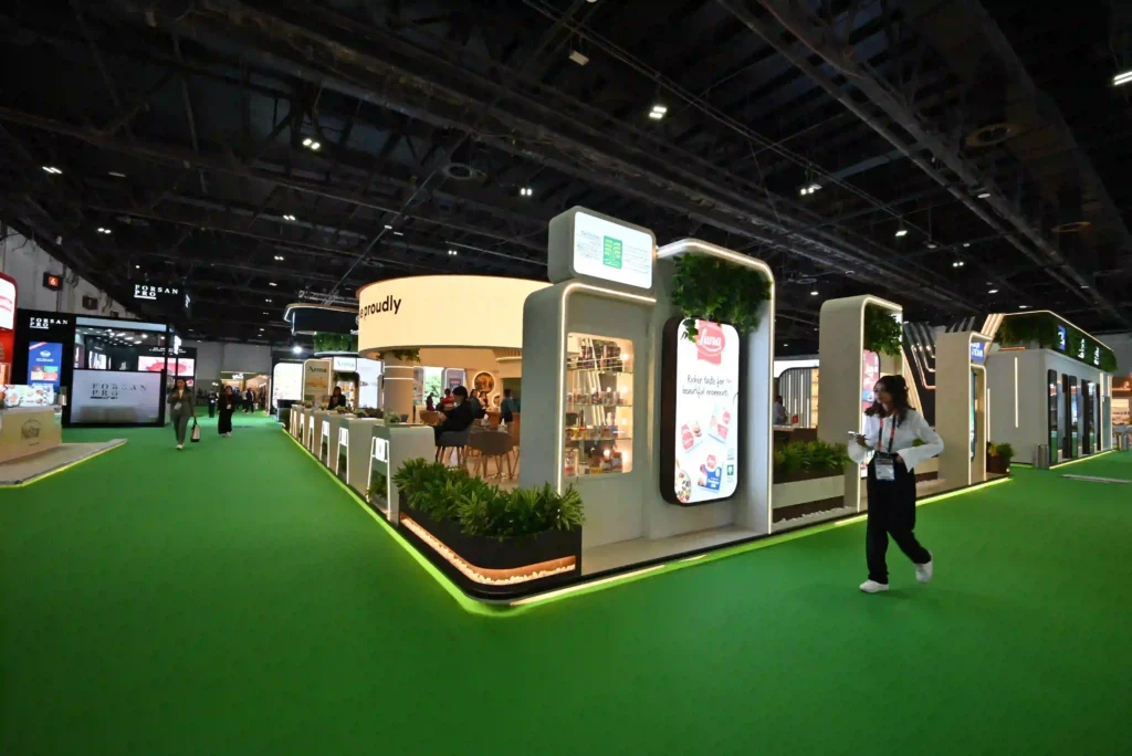 Contemporary custom exhibition stand featuring digital displays, greenery, and visitor areas