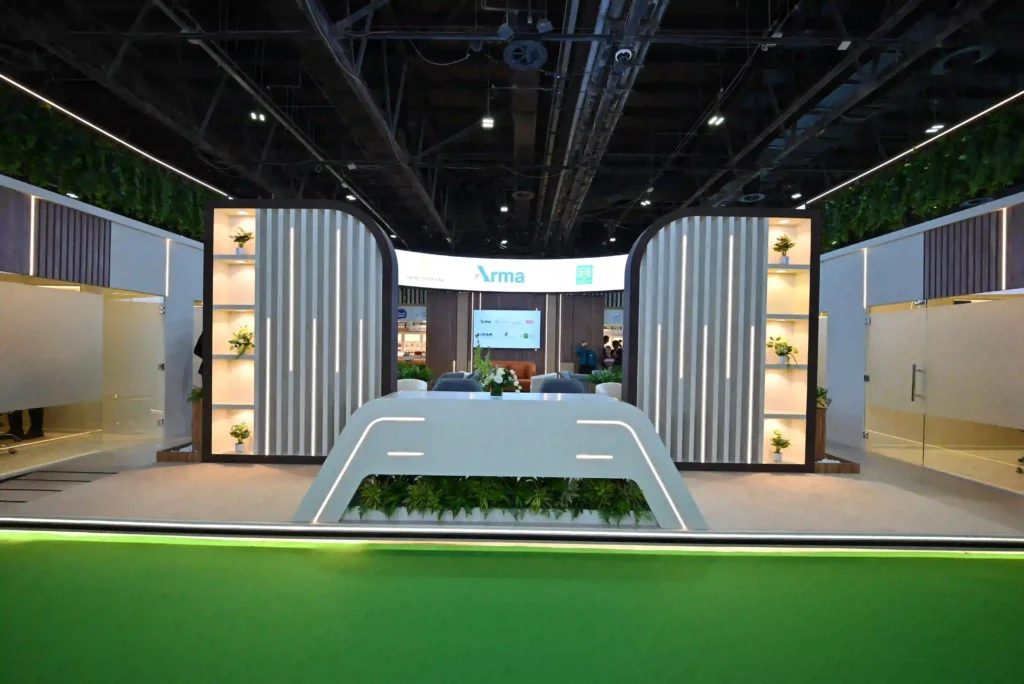 Front view of custom exhibition stand with illuminated panels and reception desk
