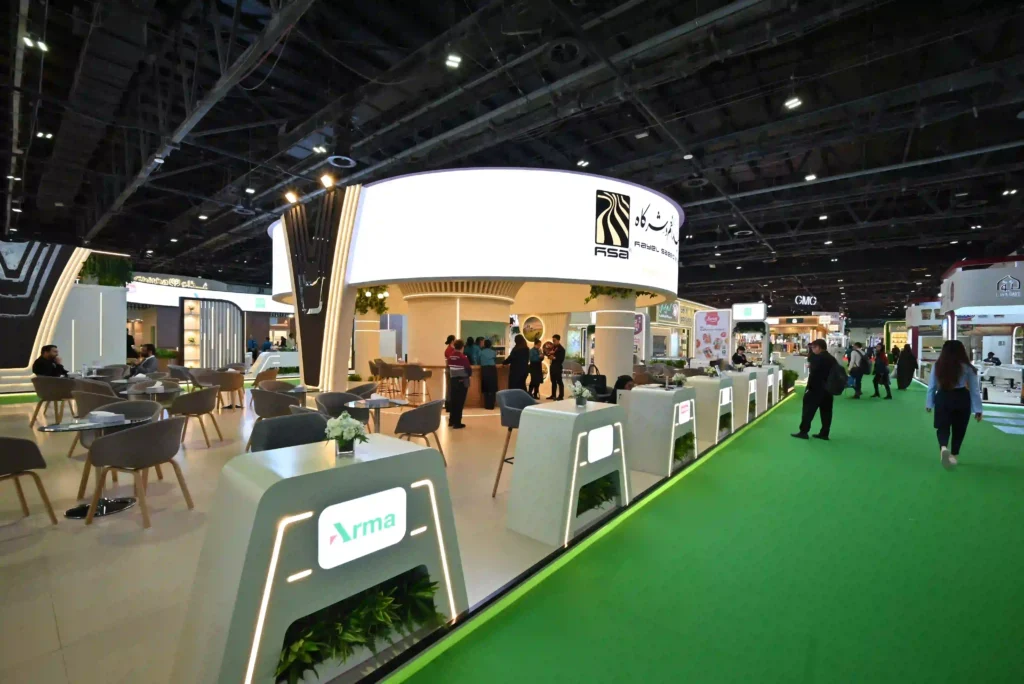 Modern trade show booth with branded reception counters and open visitor seating