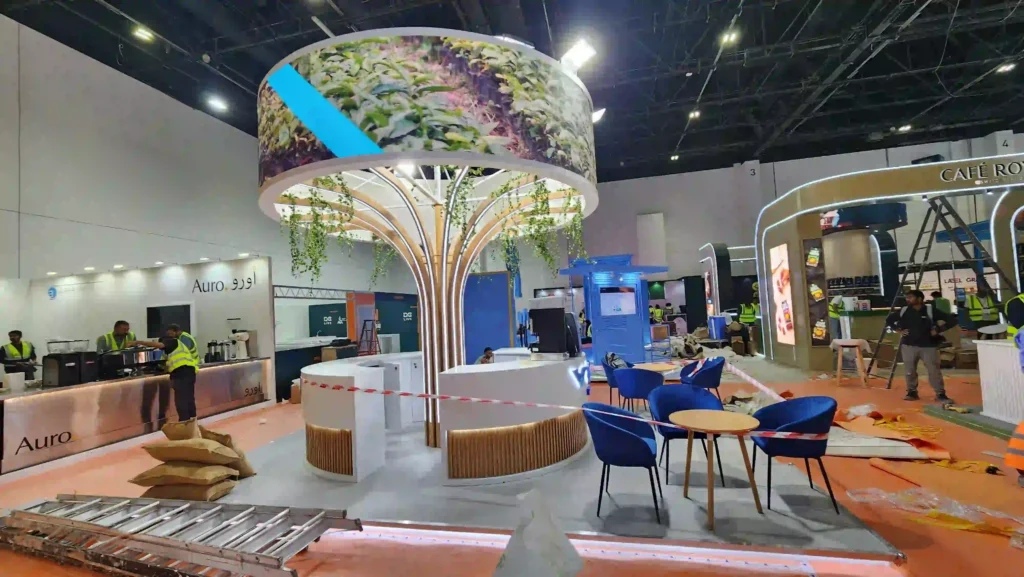 Custom trade show booth setup featuring a sculptural canopy and curved reception counters