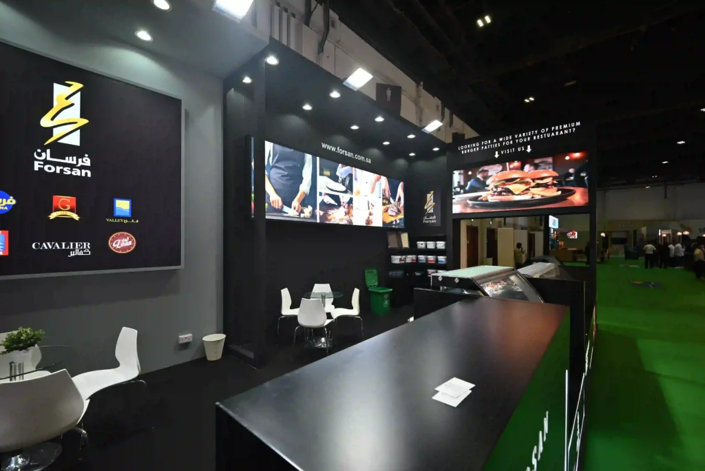 Forsan Pro event setup featuring branded reception counter, seating, and digital displays.