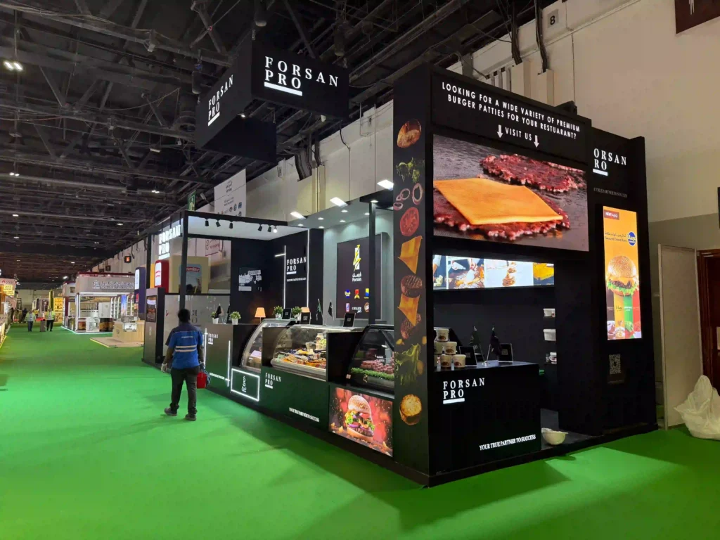 Forsan Pro trade show booth featuring digital screens, product showcases, and branded signage