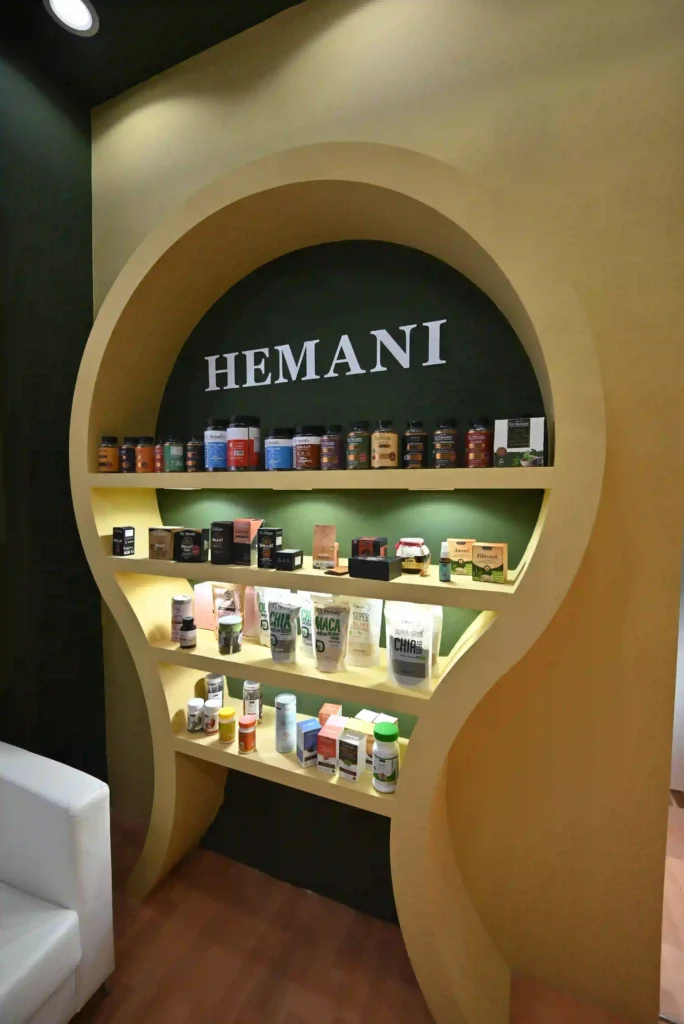 Hemani exhibition display featuring curved illuminated shelves for wellness product presentation