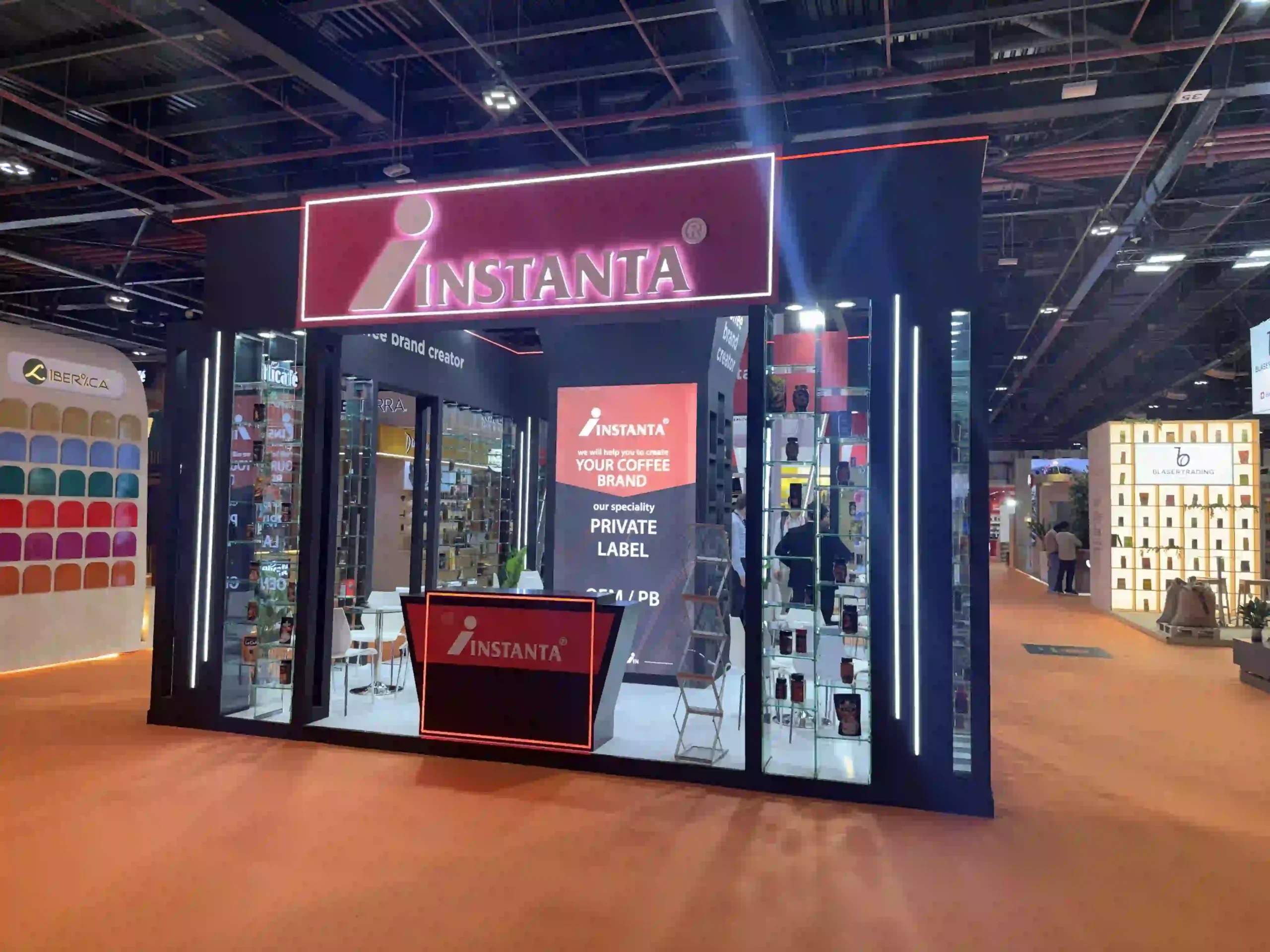 Instanta custom exhibition stand featuring illuminated branding, product displays, and reception counter