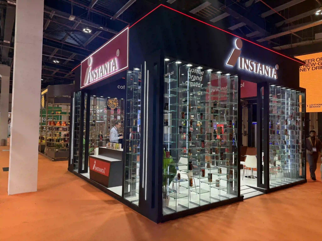 Instanta exhibition booth featuring illuminated signage, glass displays, and product showcase
