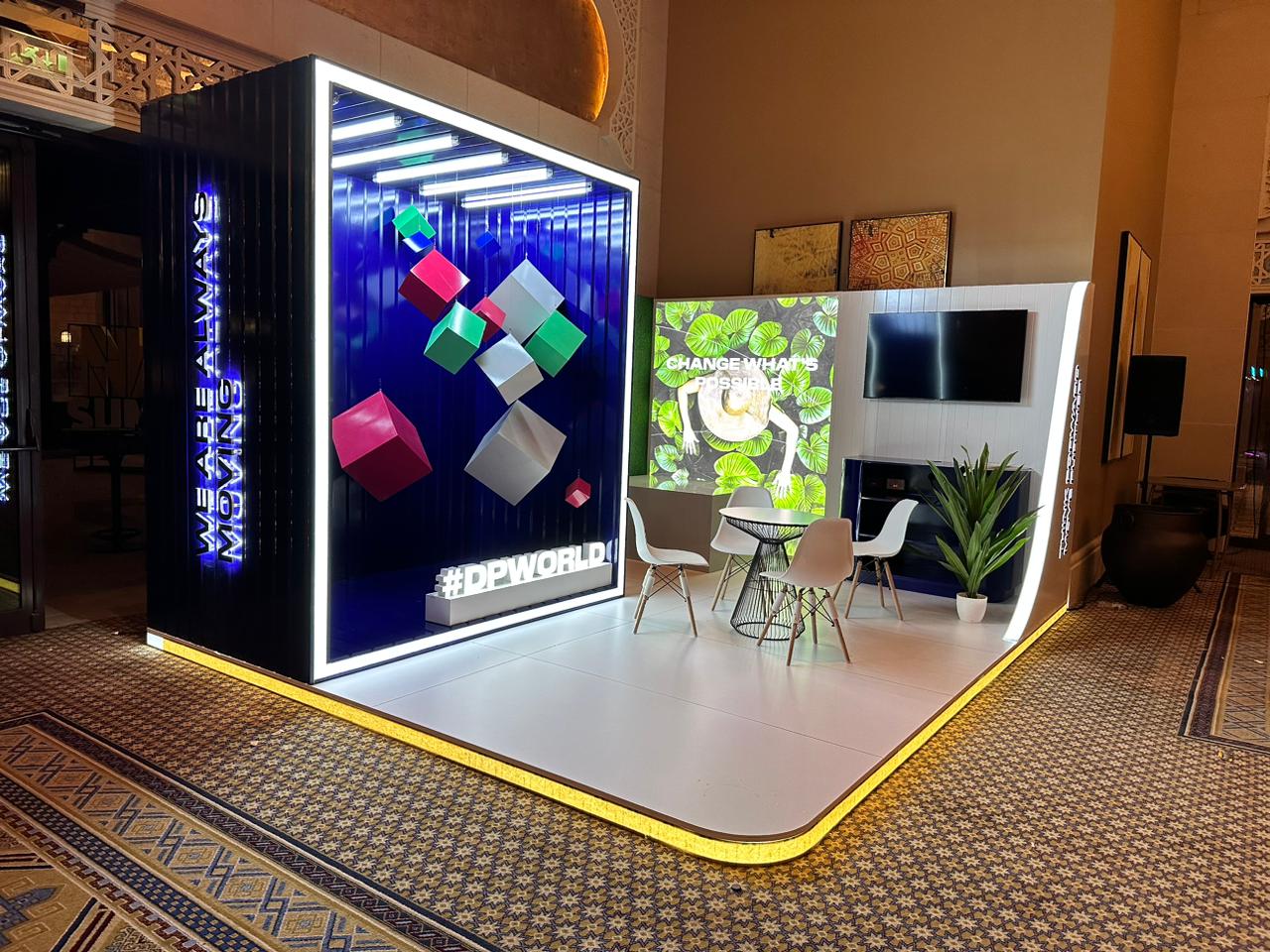 DP World exhibition stand featuring illuminated geometric displays and a modern seating area.