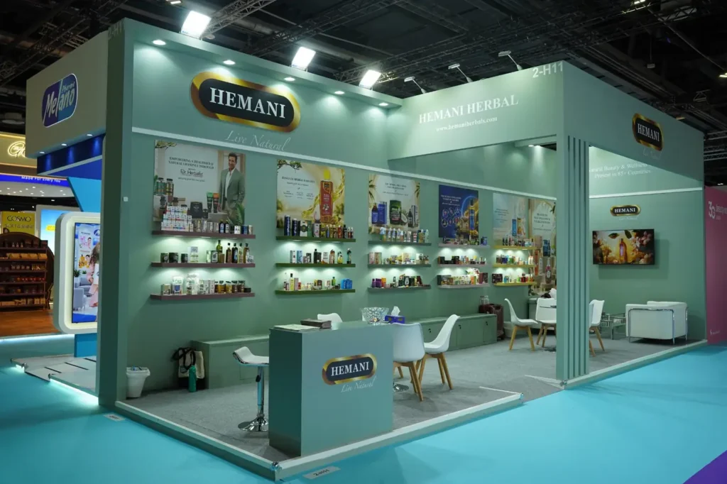 Hemani Herbal exhibition stand featuring mint green walls, product shelves, and visitor seating