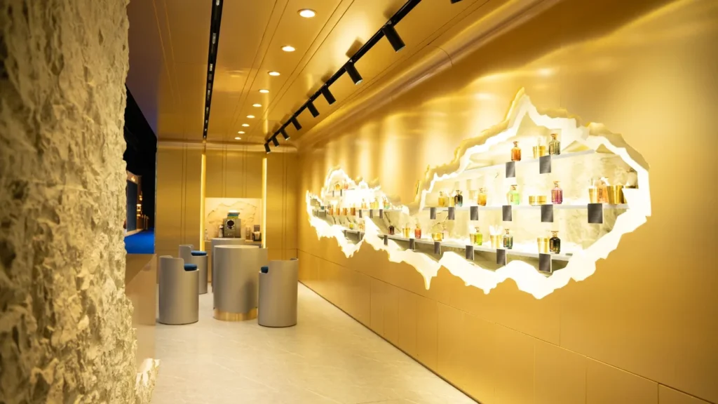 Luxury exhibition stand featuring gold finishes, illuminated product displays, and modern seating.