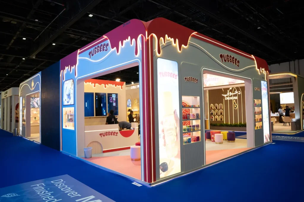 Tubbees exhibition stand featuring illuminated red and cream arches with colorful product displays.