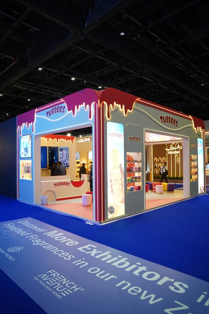 Tubbees exhibition booth with illuminated product shelves, colorful seating, and branded display panels.